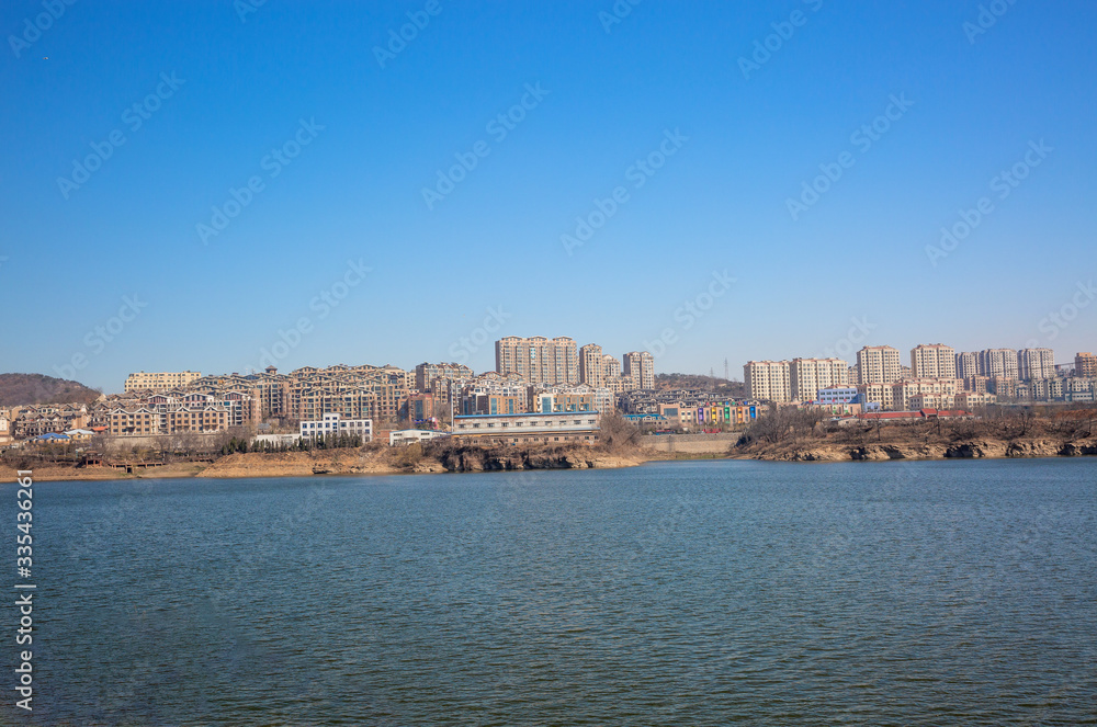 Fototapeta premium Zimowa tama na zewnątrz i miasto Xishan Lake w Dalian w Chinach