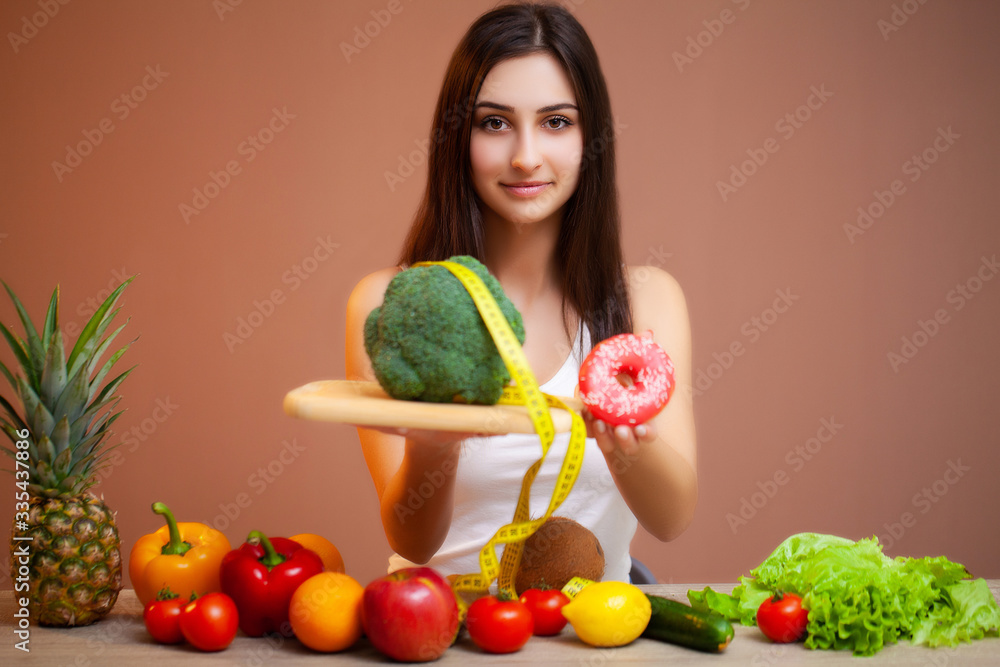 Beautiful woman who makes a choice between useful and harmful food Beautiful woman who makes a choice between useful and harmful food