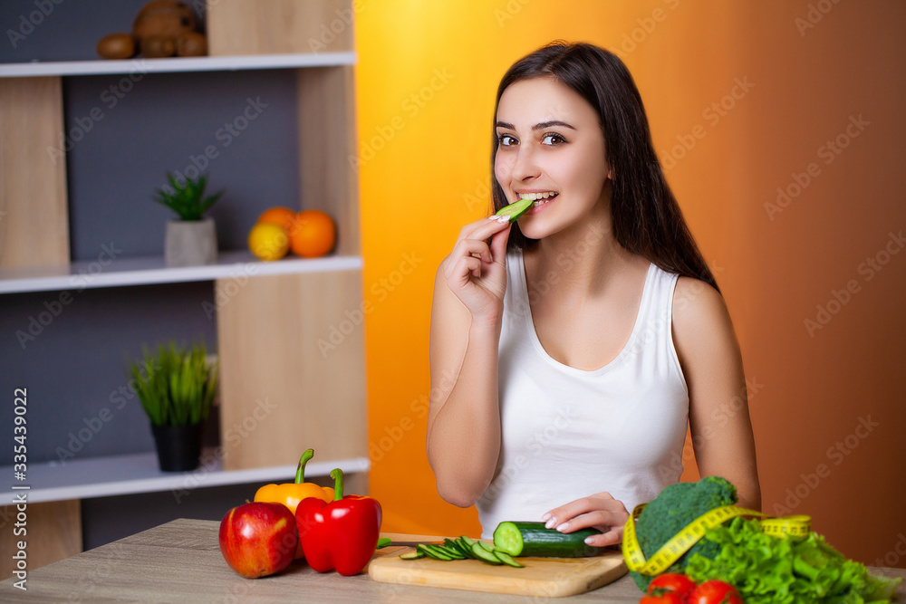 Cute woman slices cucumber for diet salad. Cute woman slices cucumber for diet salad.