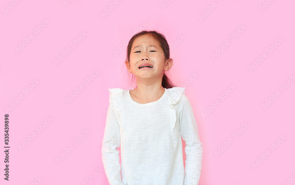 Portrait asian little child girl crying isolated on pink background. Kid with sad expressions. Portrait asian little child girl crying isolated on pink background. Kid with sad expressions.
