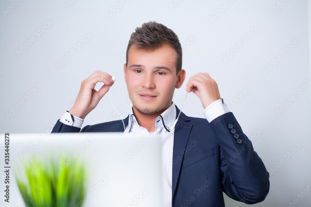 Handsome young worker working in a company office with documents and a laptop Handsome young worker working in a company office with documents and a laptop
