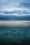 Panoramic View of Ocean with Dark Clouds Covering Sunset with clear water