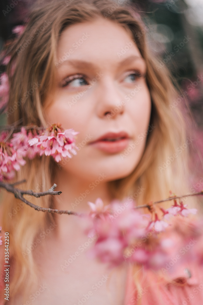 Fototapeta premium Girl in a cherry blossom garden