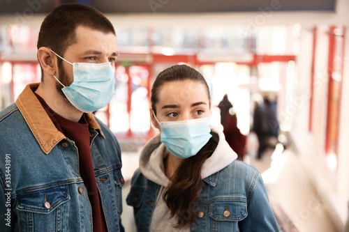 Couple wearing disposable masks in mall. Dangerous virus