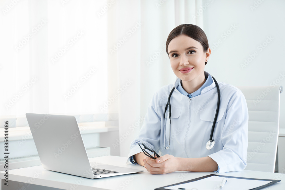Portrait of young female doctor in white coat at workplace Portrait of young female doctor in white coat at workplace