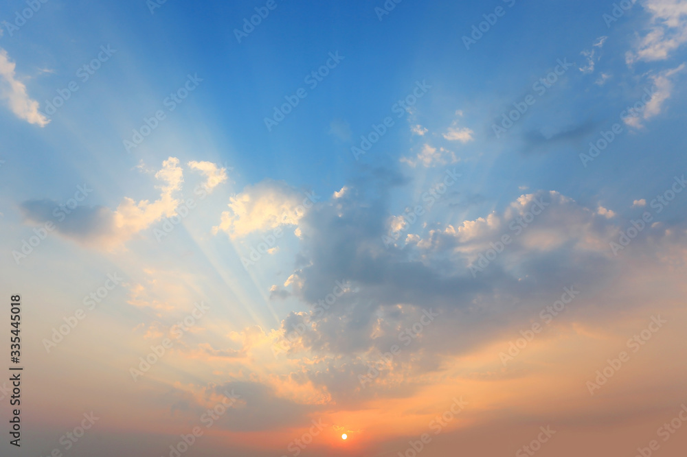 Beautiful sunlight through a clouds on blue sky background at the evening.