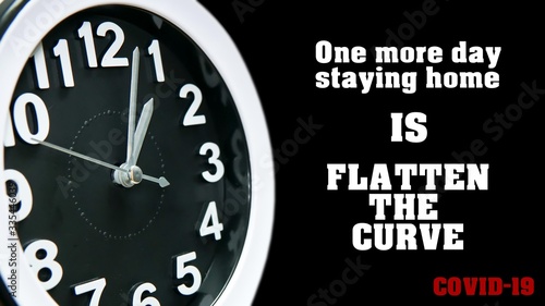 Clock dial close-up with COVID-19 pandemic quote: One more day staying home is flatten the curve. Table business timer face slogan. Quarantine time and self isolation Coronavirus concept.
