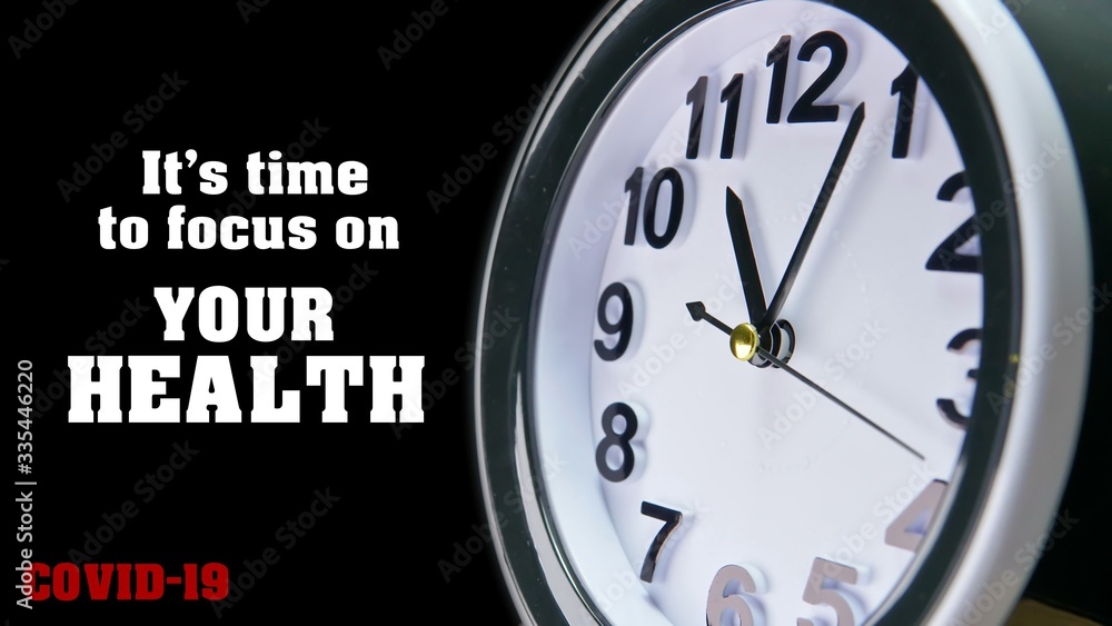 Obraz premium Clock dial close-up with COVID-19 pandemic quote: It's time to focus on your health. Table business timer face slogan. Quarantine time and self isolation for family Coronavirus concept.