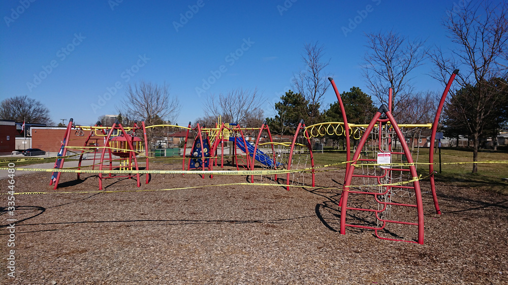 Children's playground is closed with yellow caution tape due coronavirus COVID-19 pandemic. No children allowed on the Playground  Ban on children's playgrounds. Flatten the curve fight the virus. 