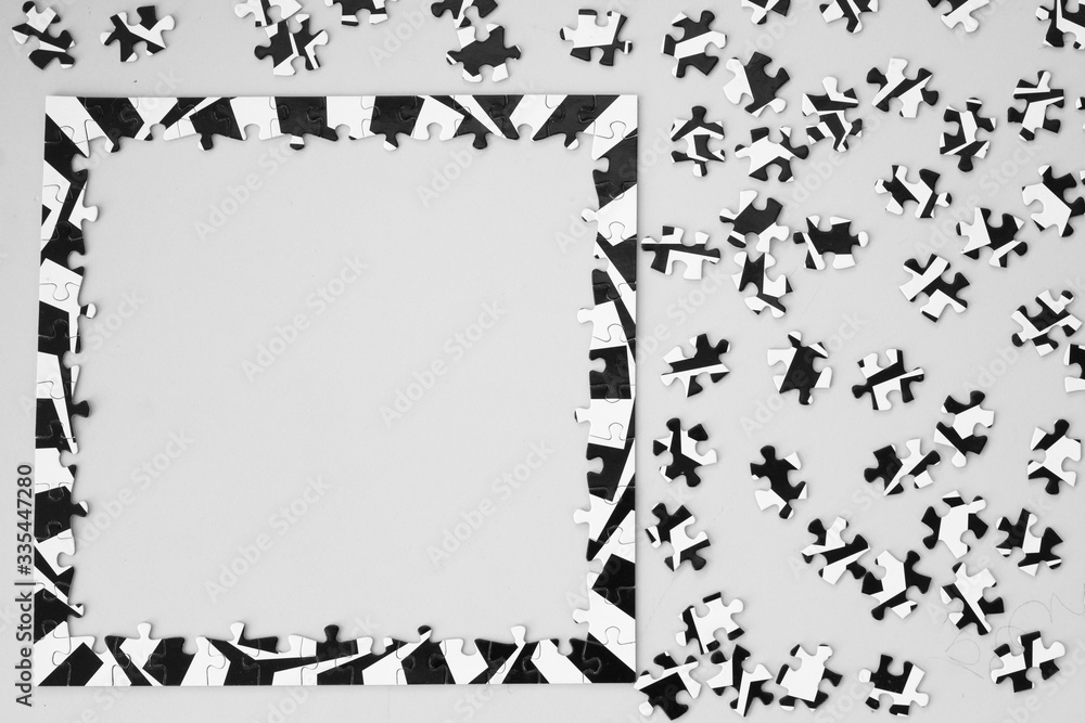 Naklejka premium Black and White Puzzle on Table from Above with Frame Completed