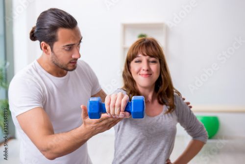 Young woman doing sport exercises with personal coach