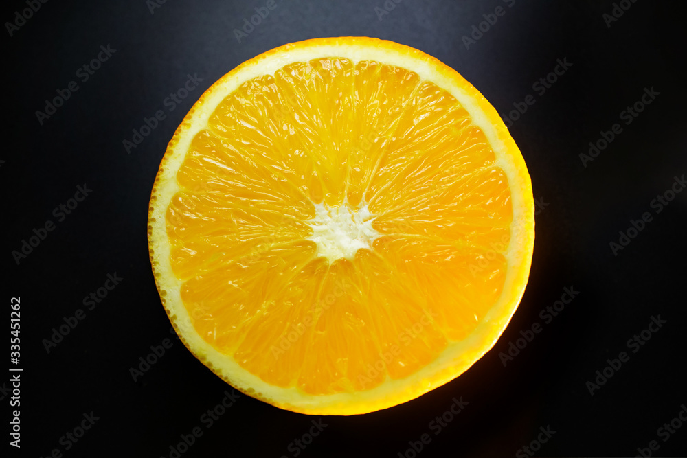 round yellow orange slice in the center of the frame on a black background close up round yellow orange slice in the center of the frame on a black background close up