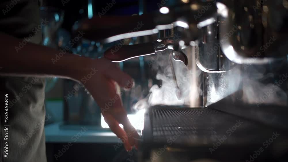 barista make hot black espresso in coffee machine