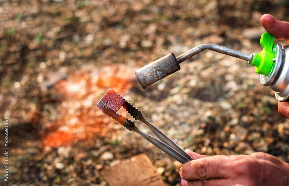 Lighting of coal for hookah on a wooden bar Lighting of coal for hookah on a wooden bar