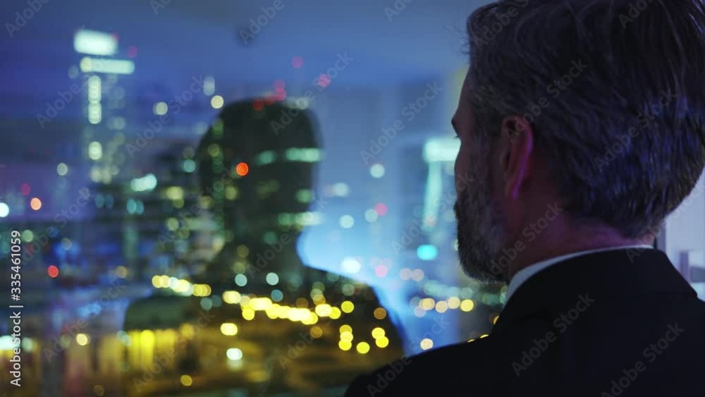 Side shot handsome bearded entrepreneur alone with his thoughts looking through window adminiring modern architecture cityscape from home. Business people concept. Side shot handsome bearded entrepreneur alone with his thoughts looking through window adminiring modern architecture cityscape from home. Business people concept.