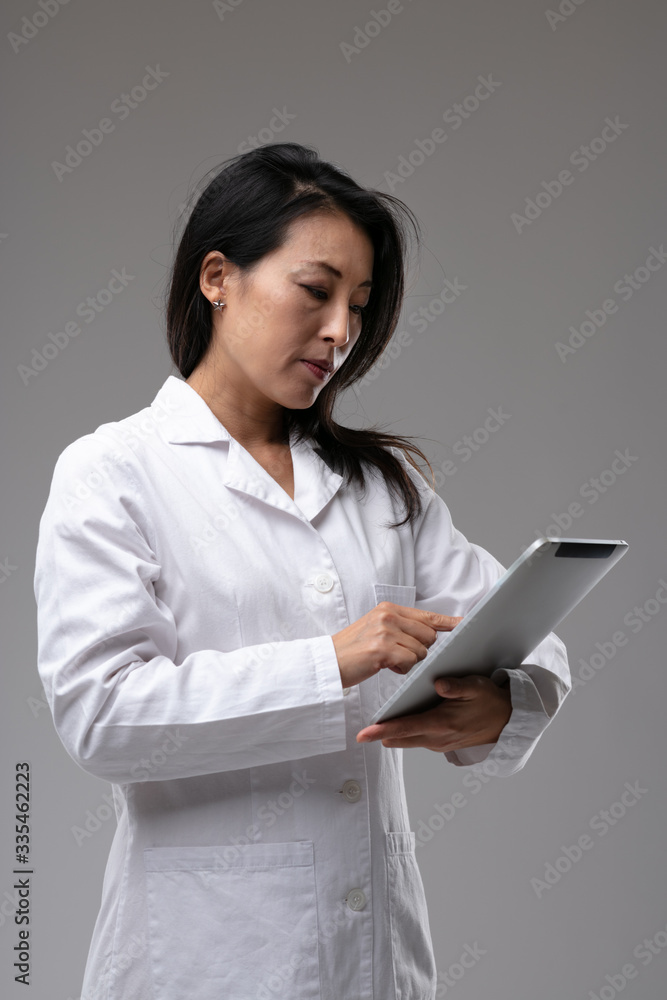 Dedicated Asian nurse or doctor checking notes Dedicated Asian nurse or doctor checking notes