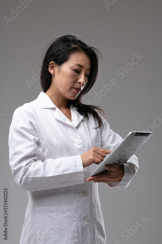 Dedicated Asian nurse or doctor checking notes