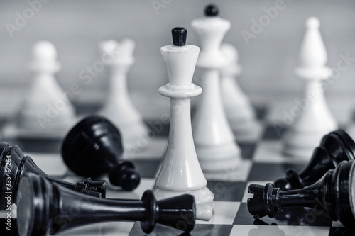The concept of team success and corporate spirit. White chess pieces on the chessboard Around them lie the defeated black pieces.
