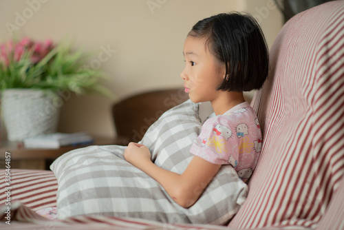 Asian child (girl) at home during lockdown, watching TV