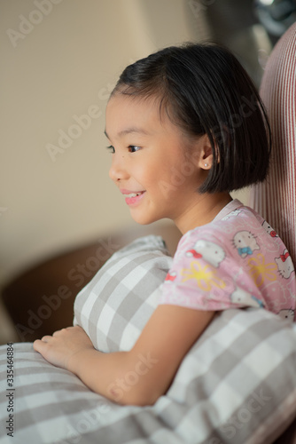 Asian child (girl) at home during lockdown, watching TV