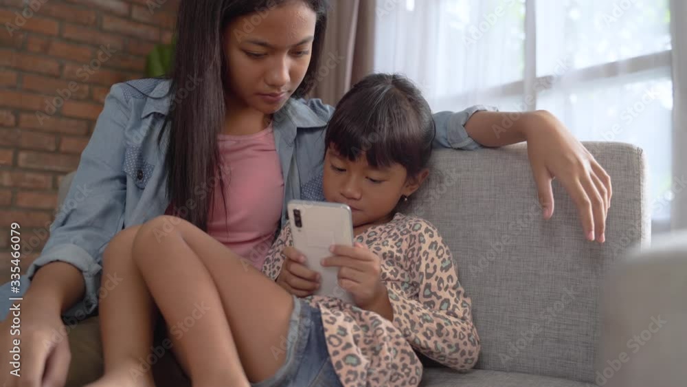 sibling different age using mobile phone together while stay home sibling different age using mobile phone together while stay home