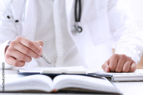 Doctor hand hold silver pen filling patient history list at clipboard pad closeup. Physical  exam  er  disease prevention  ward round  visit check  911  prescribe remedy  healthy lifestyle concept