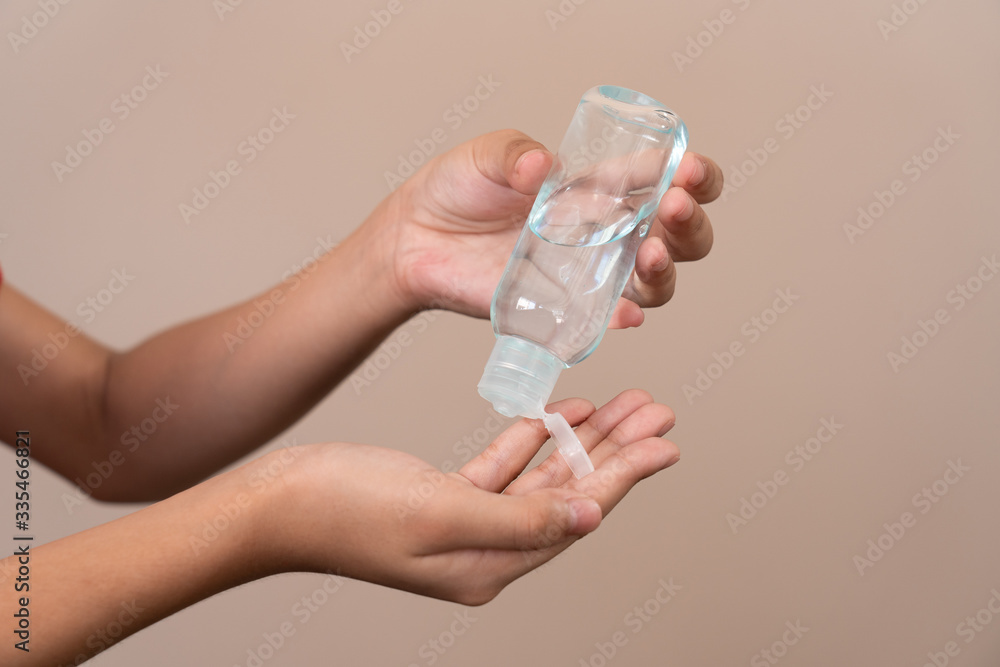 Asian girl kid using blue hand sanitizer gel in clear pump bottle , that use for killing germs, bacteria and viruses. Prevent the spread of germs and bacteria and avoid infections corona virus.