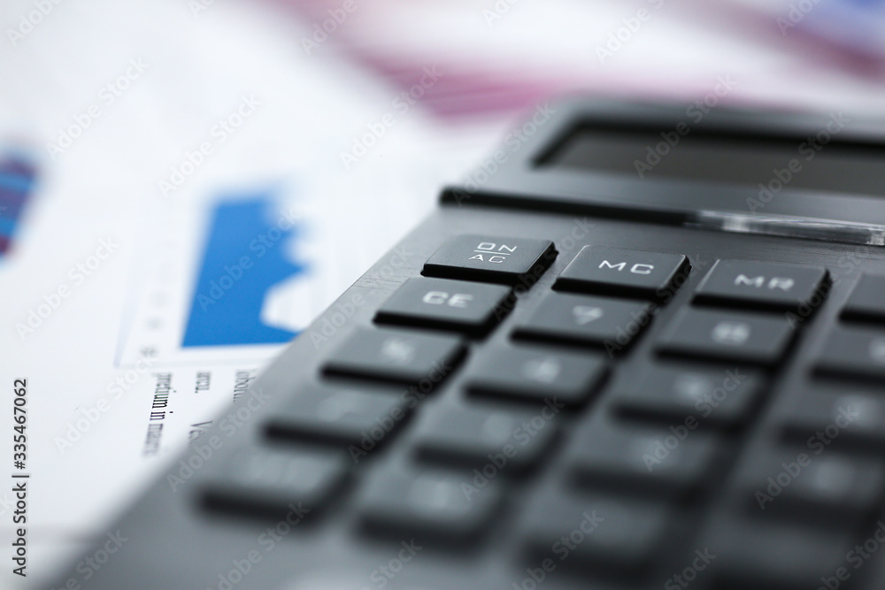 Black calculator and financial statistics on infographics at office table closeup. Internal Revenue Service inspector sum check, irs investigation, earnings, savings, loan and credit concept Black calculator and financial statistics on infographics at office table closeup. Internal Revenue Service inspector sum check, irs investigation, earnings, savings, loan and credit concept