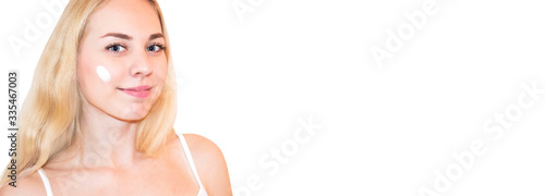Beautiful blonde woman touching her perfect soft face skin with fingers, using face cream, cosmetology procedures.Spa, skincare and wellness. Close up, background, copyspace.