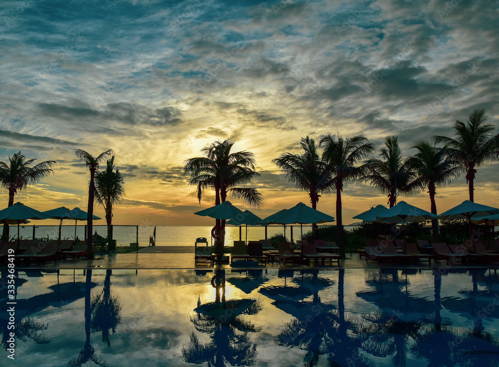 Fototapeta premium Reflection of palm trees and sky in swimming pool