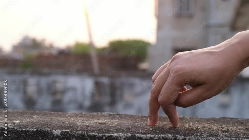 Artistic movement of the human fingers on the wall of a rooftop in slow motion in a summer afternoon. Artistic movement of the human fingers on the wall of a rooftop in slow motion in a summer afternoon.