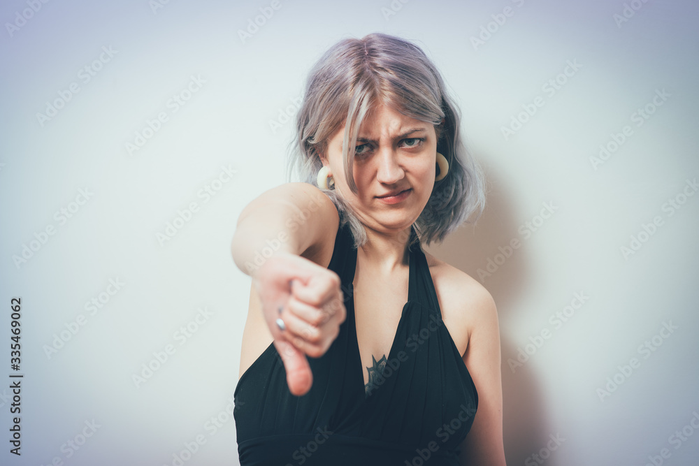 Woman showing a thumb down gesture Woman showing a thumb down gesture