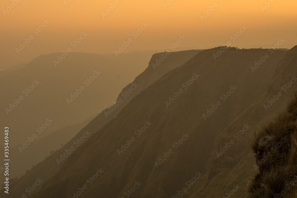 Obraz premium beautiful sunset wit orange tint over the sky and mountains