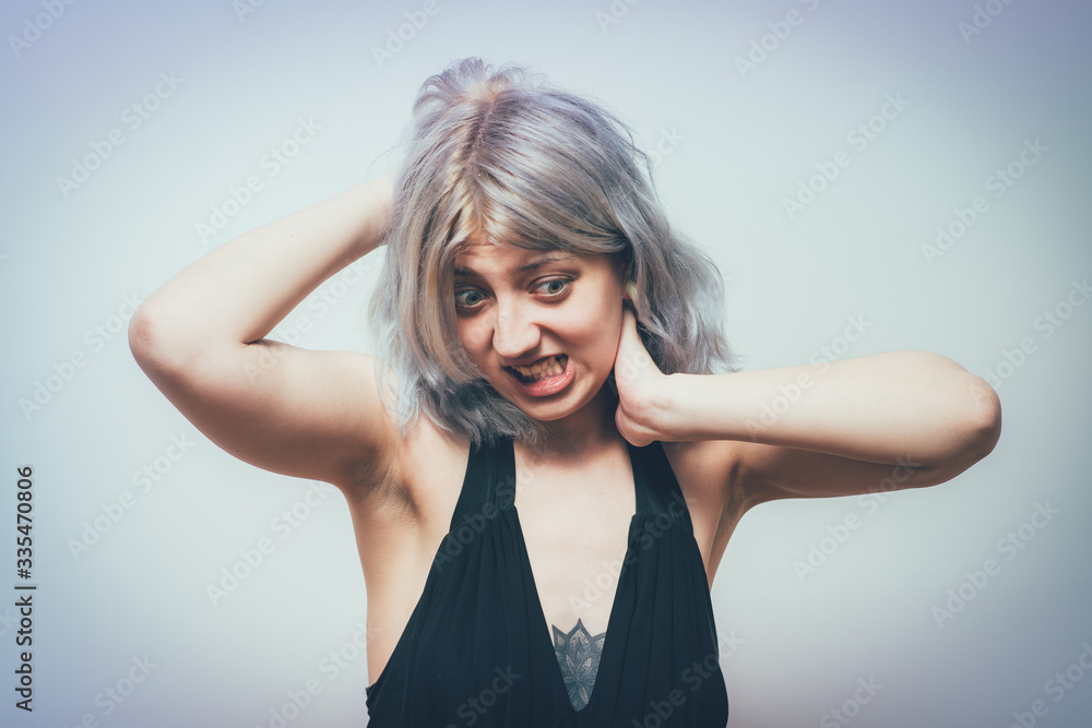 Close Up portrait stressed unhappy, young pretty woman with bad chronic neck pain, muscle sprain after long hours work, studying