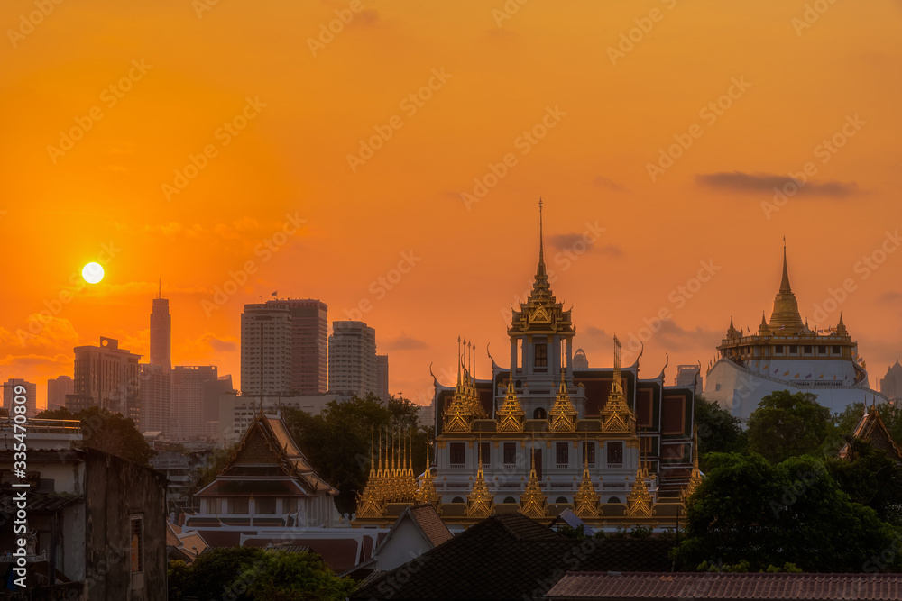 Loha Prasat Wat Ratchanatda and Golden Mountain pagoda during sunrise in Bangkok, Thailand.