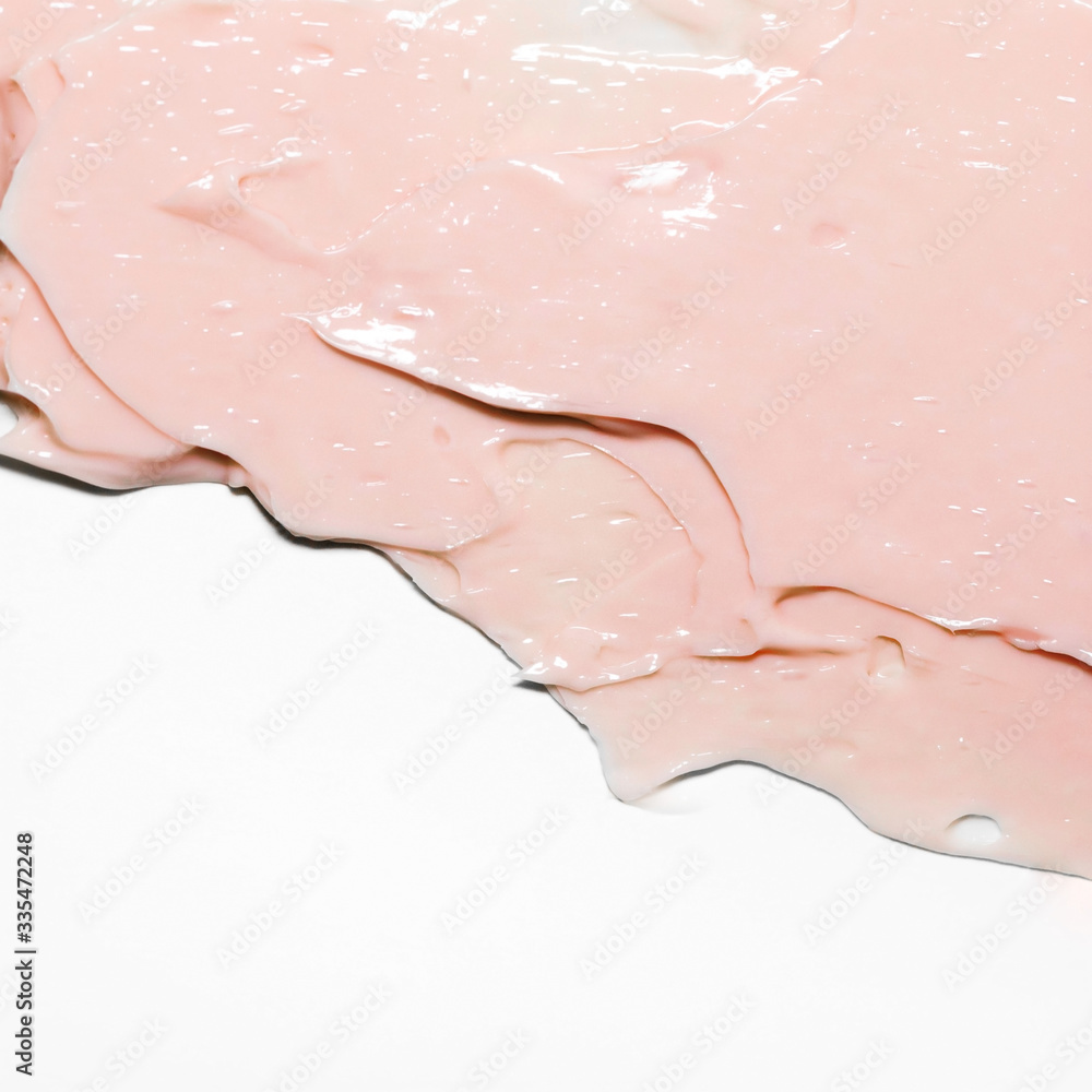 Fototapeta premium Pink cosmetic cream smear on white background. Peach color beauty creme swipe. Skincare product creamy texture. Smudge swatch. Skin care. Mask for the face or body