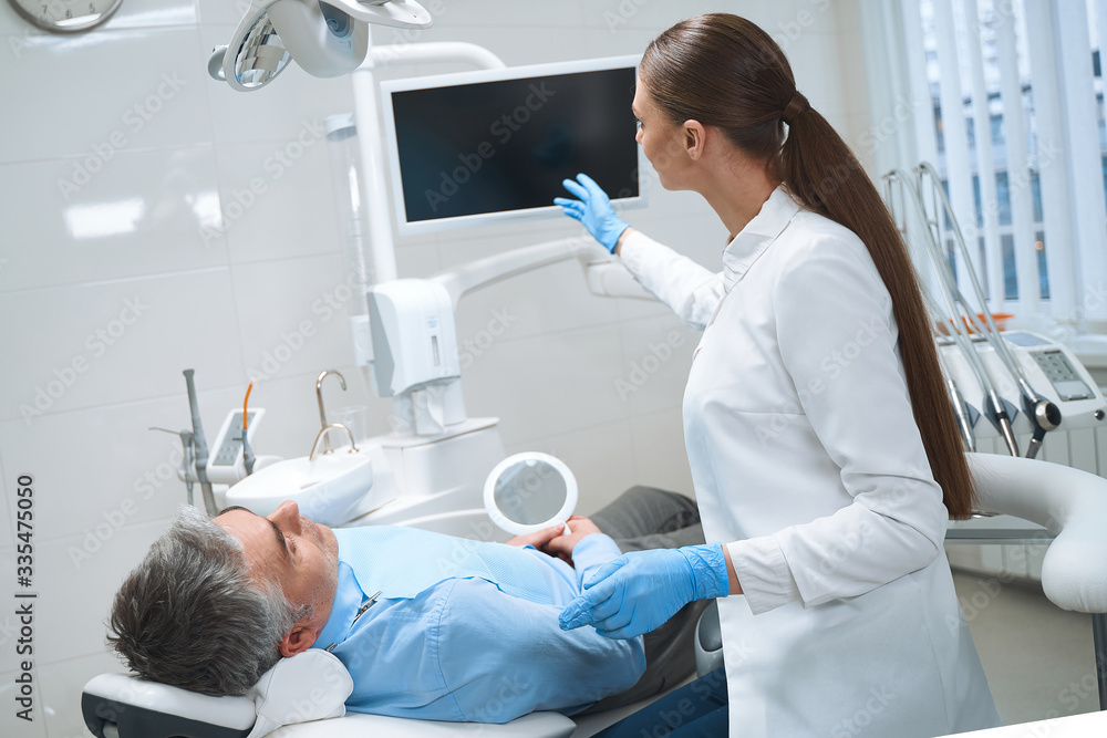 Female dentist consulting male in office stock photo Female dentist consulting male in office stock photo