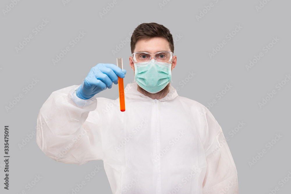 Male Laboratory Worker Showing Blood Analysis Wearing Medical Mask, Gloves and Chemical Suit. Virus, Science Concept Portrait