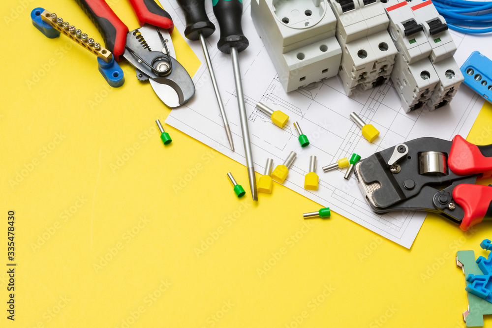 Crimping tools, electrical safety machines and power tools on a yellow background. Electrician's tools