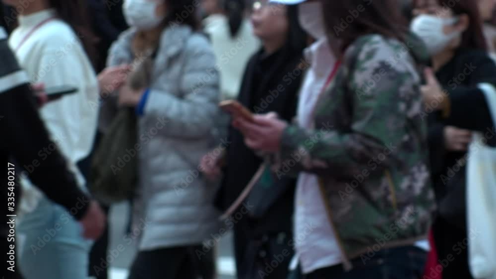 TOKYO, JAPAN - FEB 2020 : Crowd of people at Shibuya Scramble Crossing in busy weekend. Pedestrians (Japanese people and tourist) at the street. Focus in front. City lifestyle concept. Slow motion. TOKYO, JAPAN - FEB 2020 : Crowd of people at Shibuya Scramble Crossing in busy weekend. Pedestrians (Japanese people and tourist) at the street. Focus in front. City lifestyle concept. Slow motion.