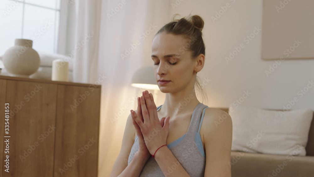 Fit young adult Caucasian female practicing yoga at home, sitting in lotus pose. Stay home, quarantine workout Fit young adult Caucasian female practicing yoga at home, sitting in lotus pose. Stay home, quarantine workout