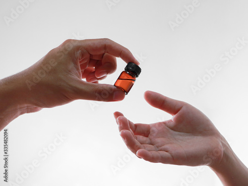 Focus on male hand giving liquid medicine bottle to the patient, corona virus or Covid-19 Vaccine, Medicine and healthcare concept photo