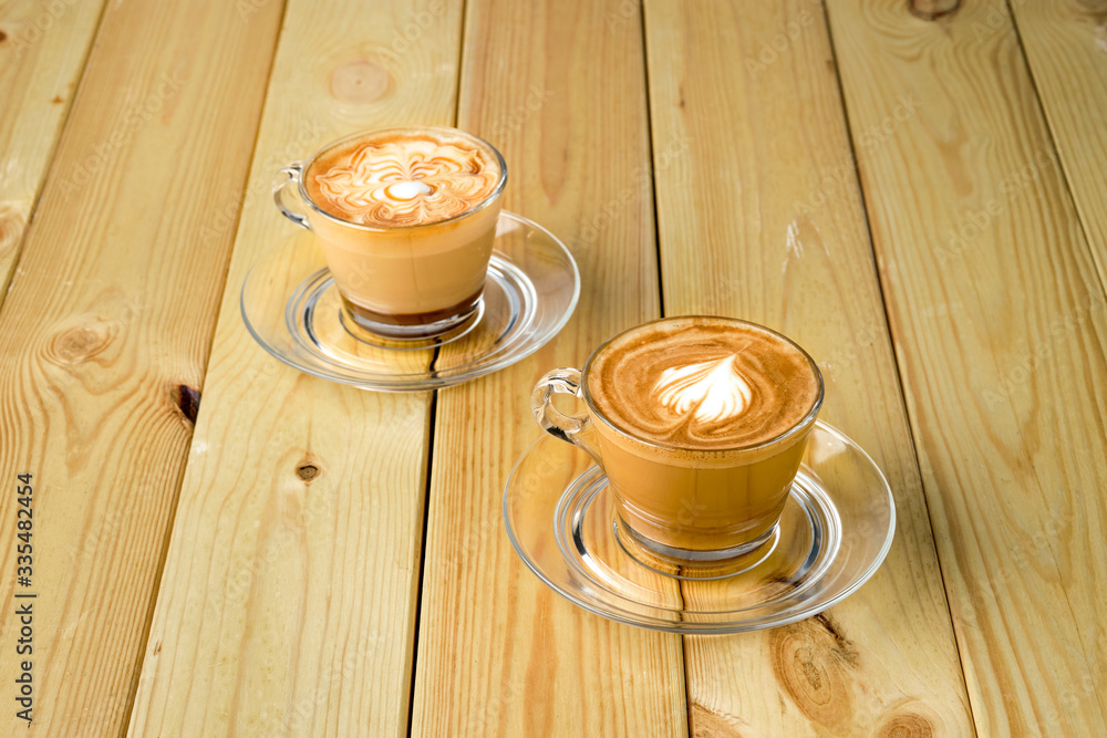 Obraz premium Cappuccino in transparent glass cup on wooden table