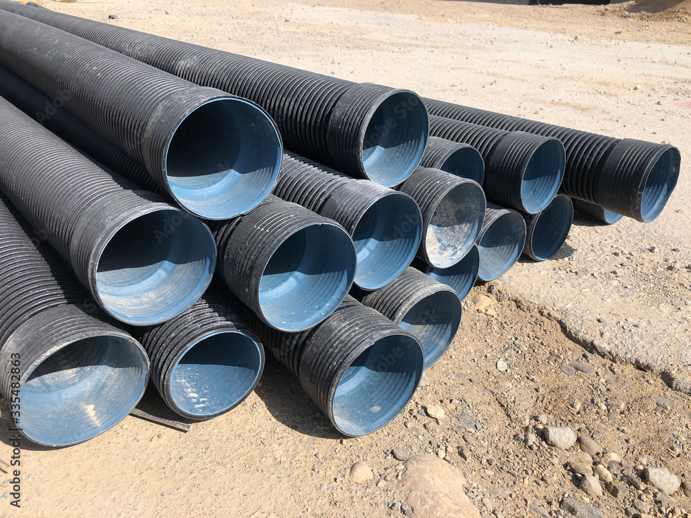 Stacked corrugated pvcpipes at the outdoor warehouse. Drainage
