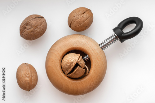 Cracking walnuts with nutcracker on white background