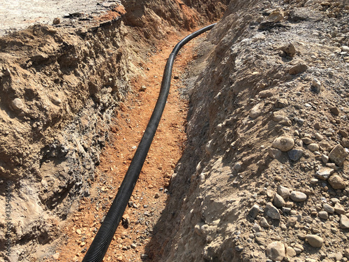 The high voltage electrical cable is laid in a trench photo