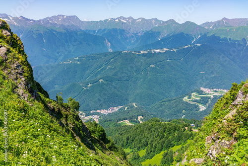 View from the heights to the Valley with residential houses, surrounded by high mountains. Krasnaya Polyana, Sochi
