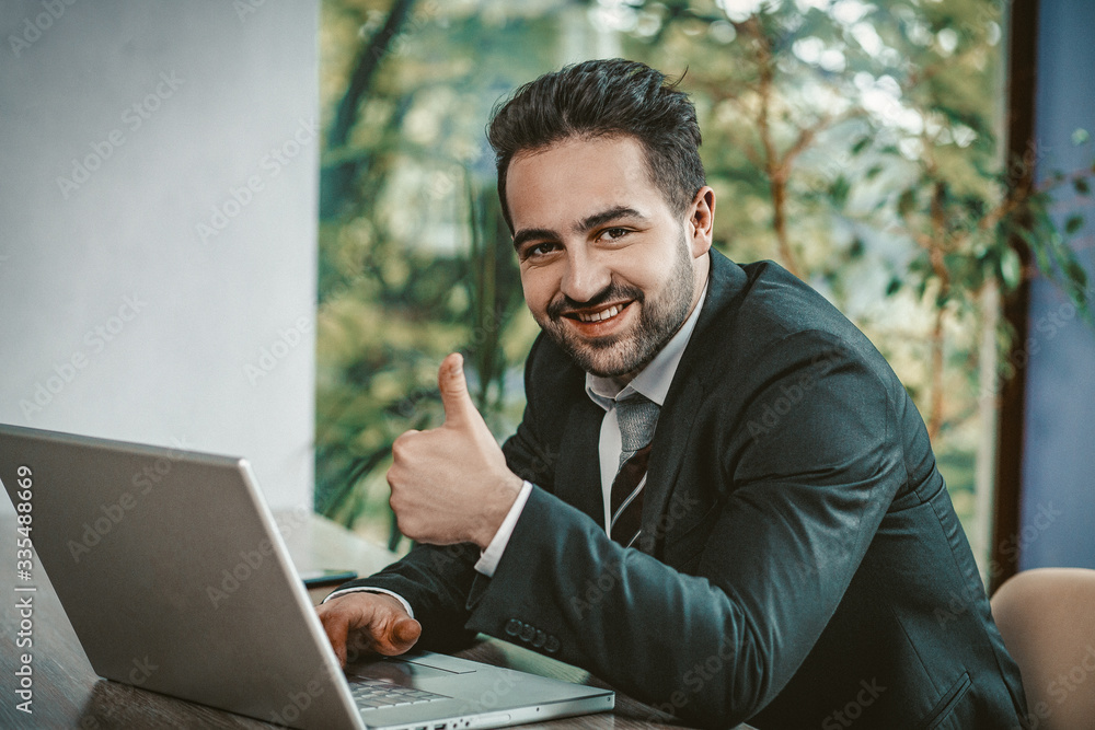 Businessman, shows, thumbs, up, sitting, laptop Businessman, shows, thumbs, up, sitting, laptop