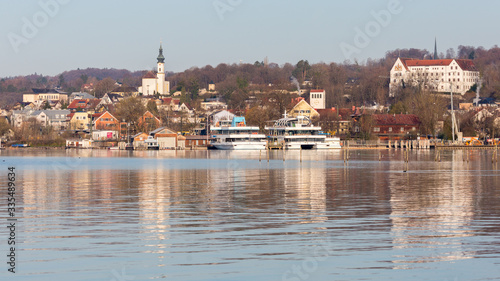 Starnberg, Bavaria / Germany - Mar 31 2020: Panorama of Starnberg. With church St. Joseph, Schloss Starnberg (Starnberg palace, on the right) and sightseeing boats. Lake in the foreground.