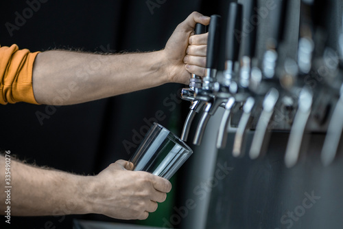bartender's hands pouring in a pint of beer